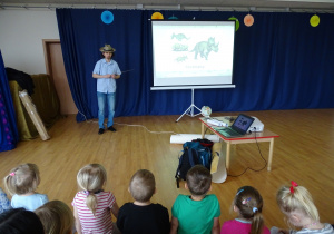 Dzieci oglądają prezentację o dinozaurach.